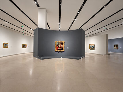 《大师之境》展览现场：宽敞展厅内，欧洲绘画作品陈列于白色与深灰色展墙上，中央为一幅金色画框的宗教题材绘画。